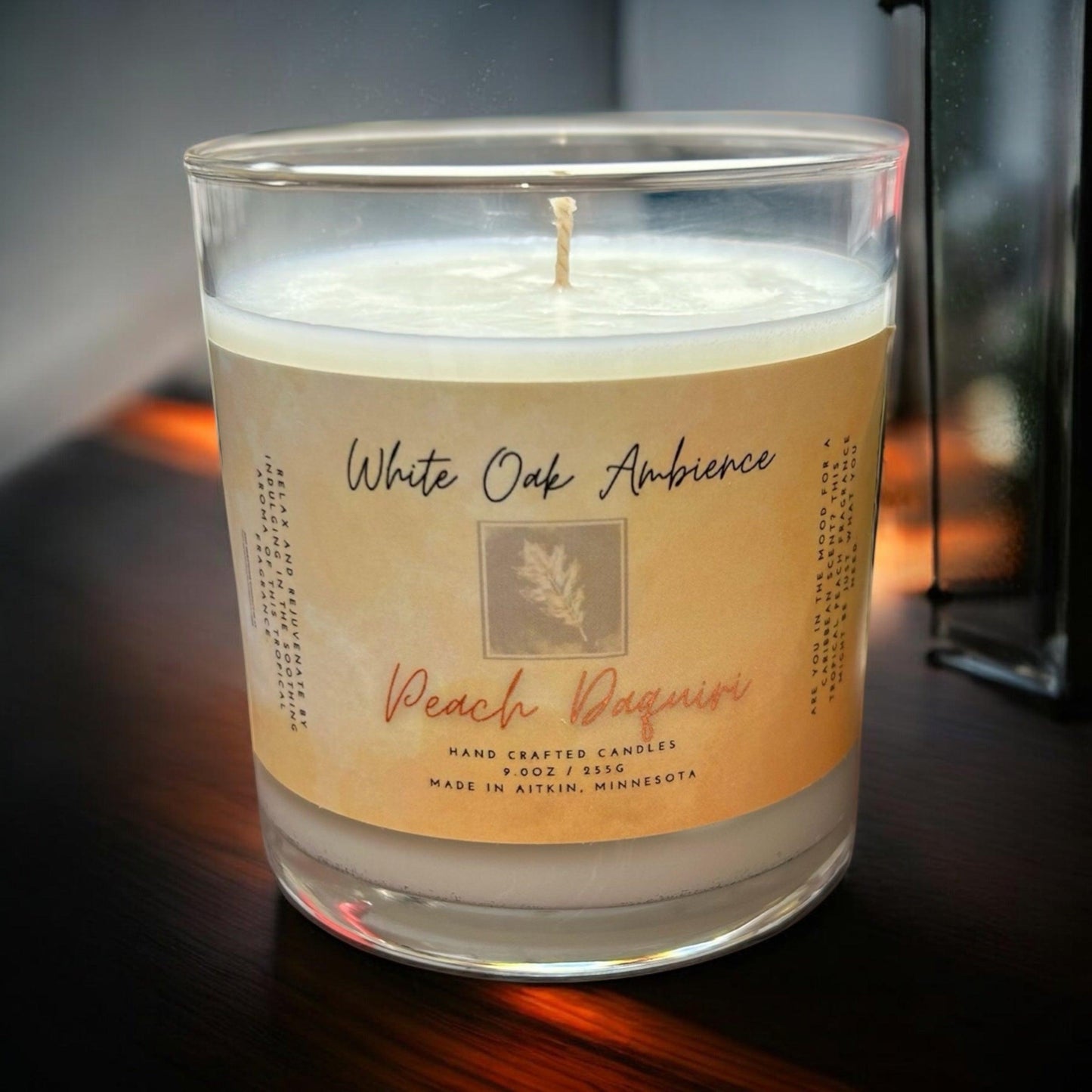 White Oak Ambience Peach Daiquiri coy candle in a clear glass jar with white wax and label, luxury scented wax for home fragrance.
