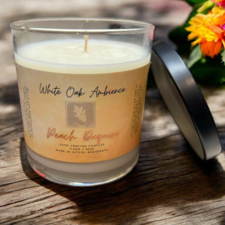 White Oak Ambience Peach Daiquiri coy candle in a clear glass jar with white wax and label, luxury scented wax for home fragrance.
