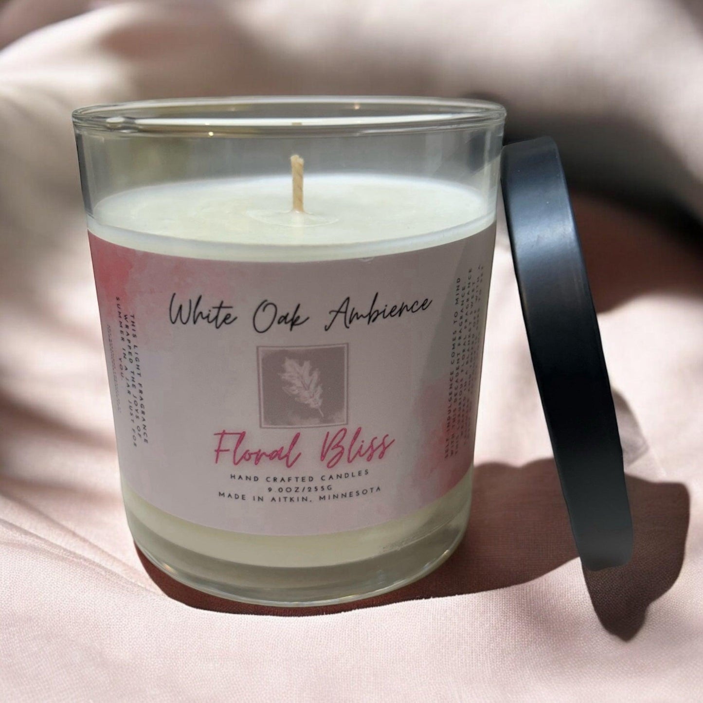 Candle with a label on a soft pink background