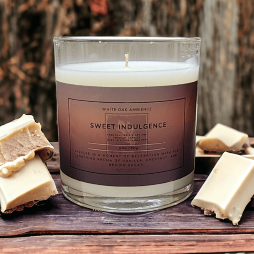 Candle labeled 'Sweet Indulgence' with soap bars on a wooden surface