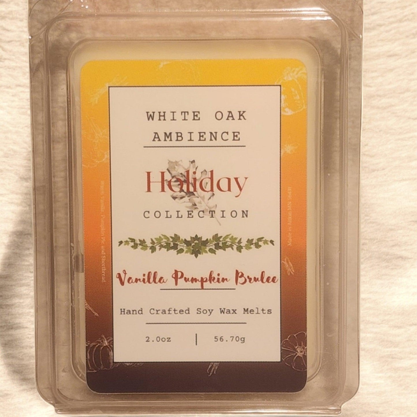 Vanilla Pumpkin Brulee wax melt packaging with 'White Oak Ambience' branding on a wooden surface.